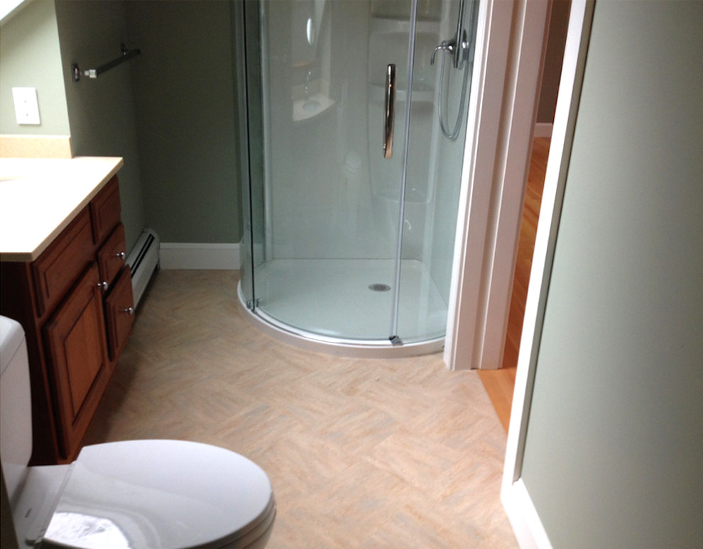 Inredning av ett klassiskt litet badrum med dusch, med ett nedsänkt handfat, luckor med profilerade fronter, skåp i mörkt trä, en hörndusch, en toalettstol med hel cisternkåpa och gröna väggar