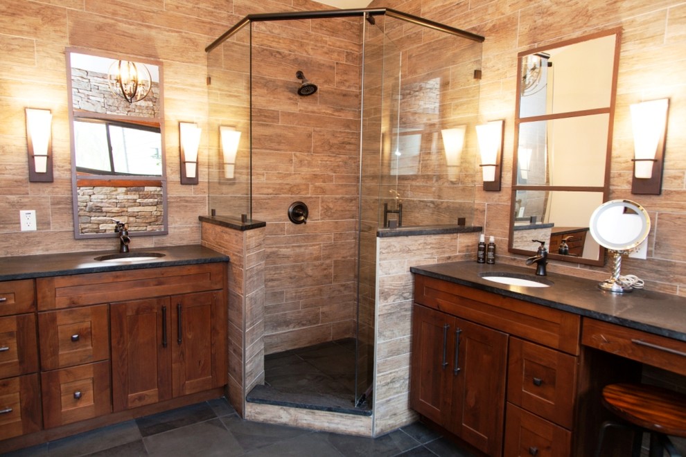 Exemple d'une salle de bain principale en bois brun avec un placard à porte affleurante, un plan de toilette en bois, une baignoire sur pieds, une douche d'angle, un carrelage gris, un lavabo encastré, WC à poser et un mur beige.