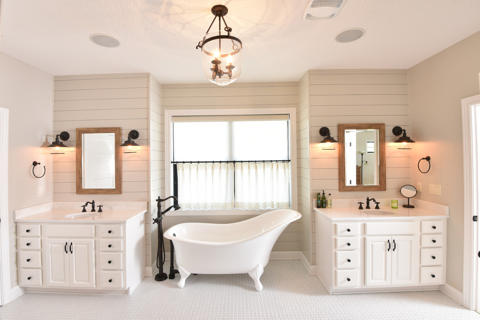 На фото: ванная комната в стиле кантри с фасадами с выступающей филенкой, белыми фасадами, отдельно стоящей ванной, белой плиткой, белыми стенами, монолитной раковиной и белым полом с