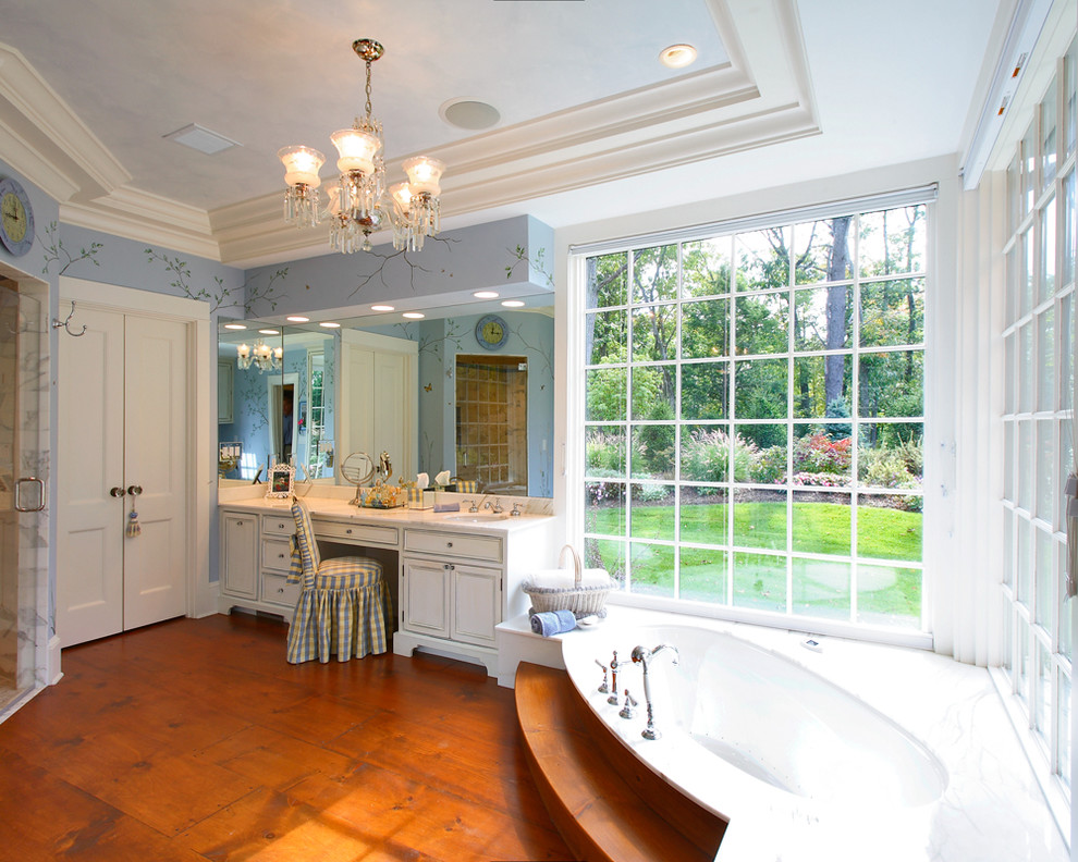 Large arts and crafts master medium tone wood floor and brown floor bathroom photo in New York with raised-panel cabinets, white cabinets, blue walls, an undermount sink, marble countertops and a hinged shower door