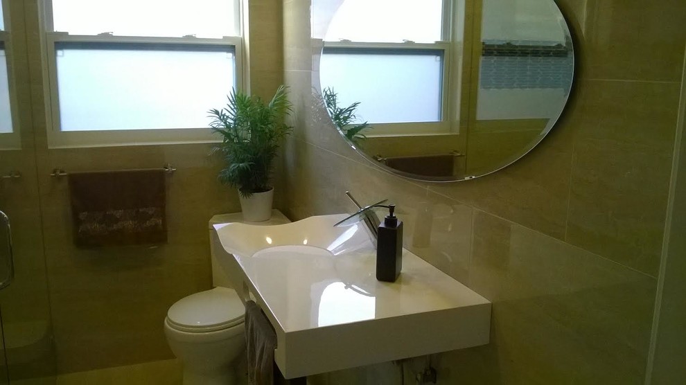 Пример оригинального дизайна: главная ванная комната среднего размера в современном стиле с подвесной раковиной, бежевыми стенами, столешницей из искусственного камня, белой столешницей и бежевой плиткой