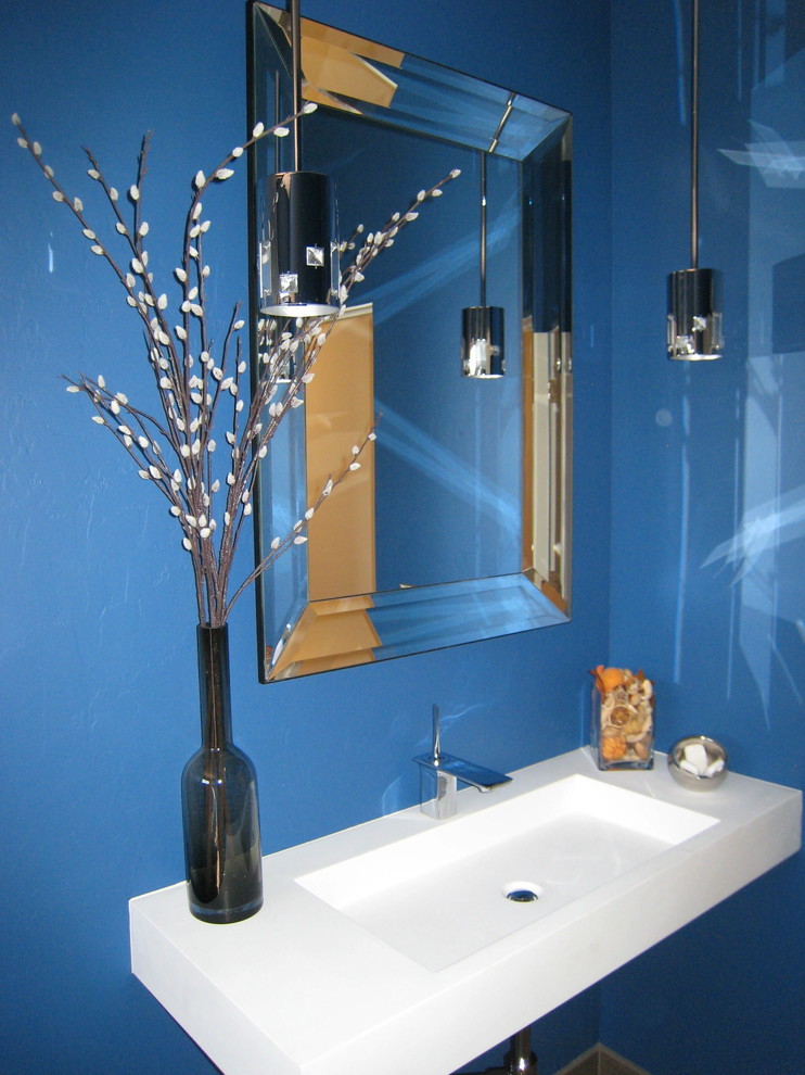 Inredning av ett modernt mellanstort vit vitt en-suite badrum, med ett väggmonterat handfat, blå väggar och bänkskiva i akrylsten