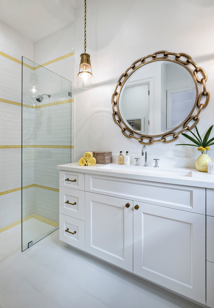 Foto på ett maritimt vit badrum, med luckor med infälld panel, vita skåp, en kantlös dusch, vit kakel, gul kakel, vita väggar, ett undermonterad handfat, vitt golv och med dusch som är öppen