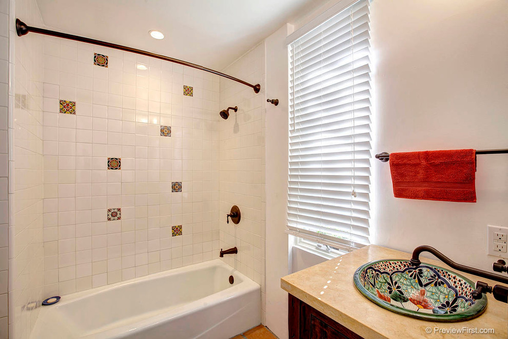 Idéer för att renovera ett mellanstort medelhavsstil badrum, med ett fristående handfat, luckor med infälld panel, skåp i mörkt trä, ett badkar i en alkov, en dusch/badkar-kombination, vit kakel och vita väggar
