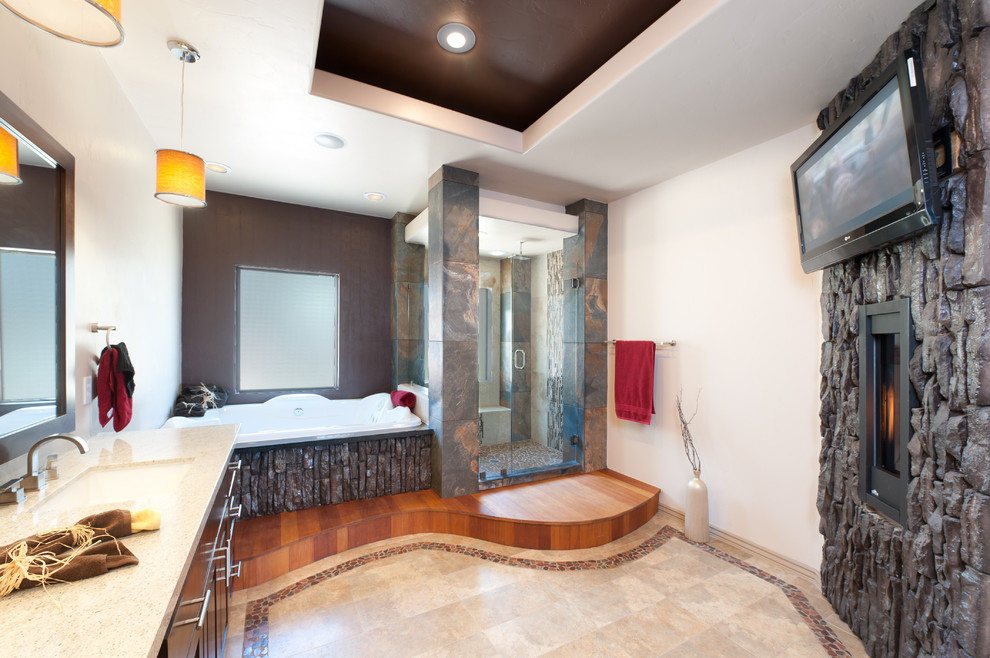 Cette image montre une grande salle de bain principale design en bois brun avec une baignoire posée, un placard à porte plane, une douche d'angle, un carrelage marron, un carrelage multicolore, du carrelage en ardoise, un mur multicolore, un sol en carrelage de porcelaine, un lavabo encastré, un plan de toilette en surface solide, un sol beige, une cabine de douche à porte battante et une fenêtre.