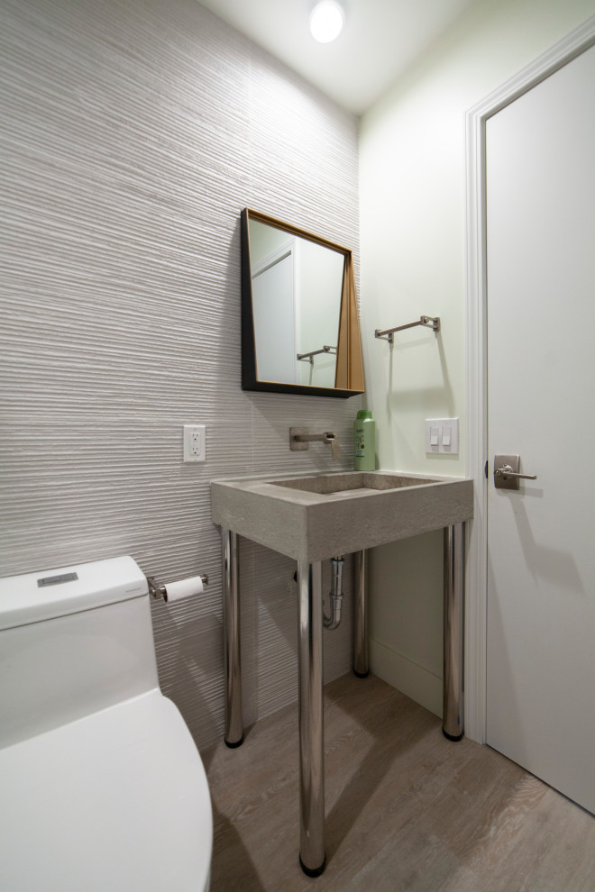 Mid-sized island style 3/4 beige tile beige floor and single-sink alcove shower photo in Orange County with a one-piece toilet, beige walls, a pedestal sink, a hinged shower door and a freestanding vanity