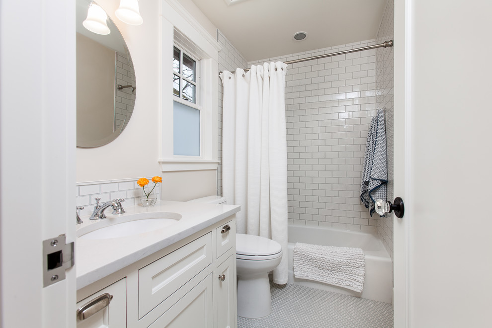 Design ideas for a small traditional ensuite bathroom in Portland with recessed-panel cabinets, white cabinets, a built-in bath, a shower/bath combination, a two-piece toilet, white tiles, metro tiles, white walls, ceramic flooring, a submerged sink, quartz worktops, multi-coloured floors and a shower curtain.