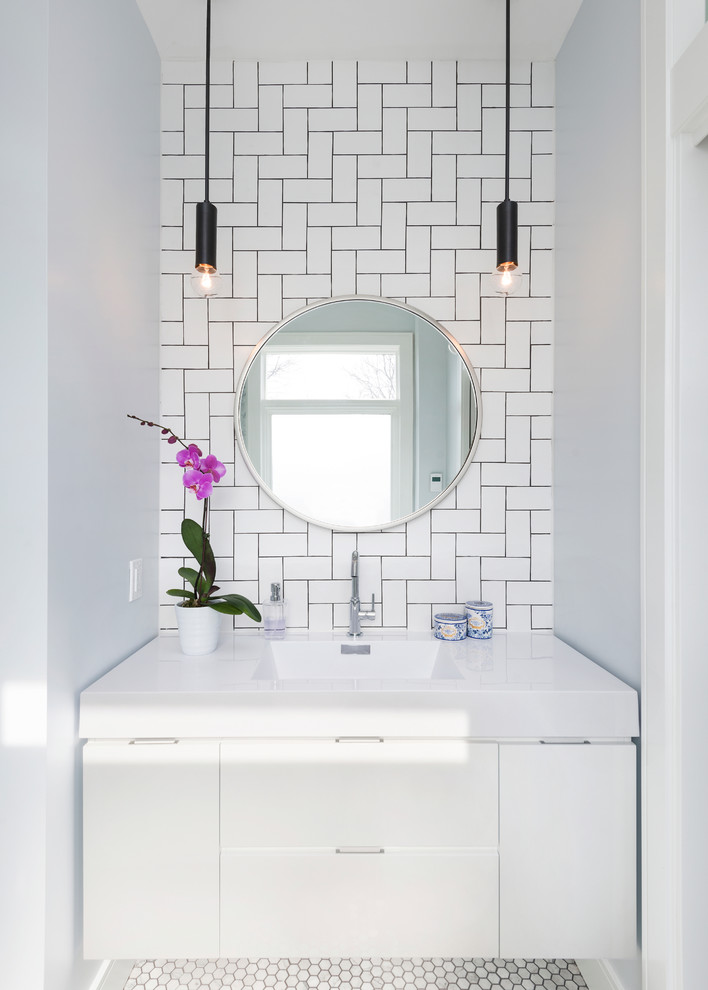 На фото: маленькая главная ванная комната в современном стиле с плоскими фасадами, белыми фасадами, белой плиткой, плиткой кабанчик, белыми стенами, мраморным полом, монолитной раковиной, столешницей из искусственного камня и зеркалом с подсветкой для на участке и в саду