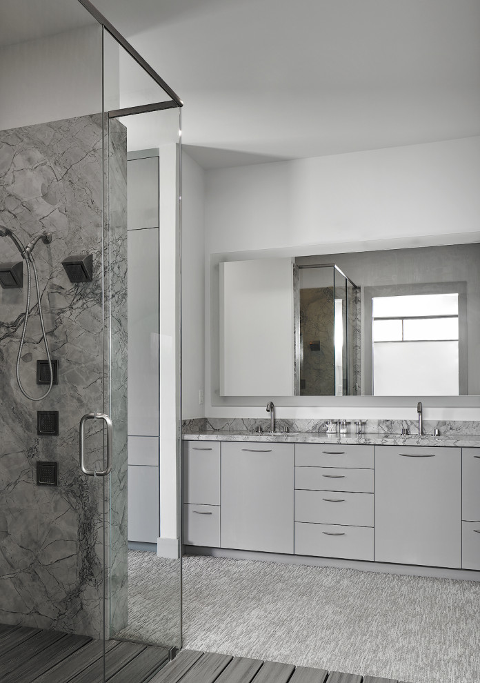Idéer för att renovera ett mycket stort funkis grå grått en-suite badrum, med släta luckor, grå skåp, en dusch i en alkov, en vägghängd toalettstol, grå kakel, stenhäll, grå väggar, ett undermonterad handfat, bänkskiva i kvartsit, grått golv och dusch med gångjärnsdörr