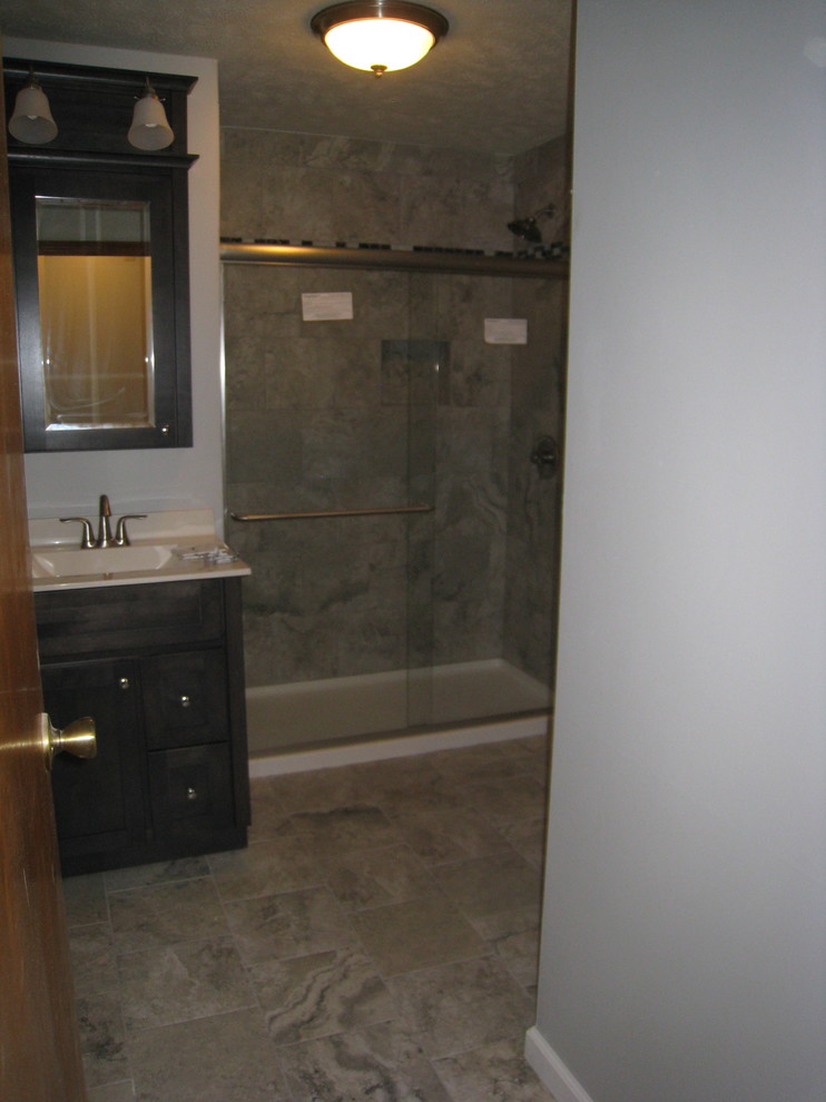 Mittelgroßes Modernes Duschbad mit grauen Schränken, Duschnische, Wandtoilette mit Spülkasten, grauer Wandfarbe, Porzellan-Bodenfliesen, integriertem Waschbecken, Mineralwerkstoff-Waschtisch und Schiebetür-Duschabtrennung in Sonstige