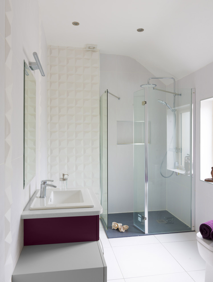 Idée de décoration pour une salle d'eau design de taille moyenne avec un placard à porte plane, des portes de placard violettes, un espace douche bain, WC à poser, un carrelage blanc, des carreaux de porcelaine, un mur blanc, un sol en carrelage de porcelaine, un lavabo posé et un plan de toilette en quartz.