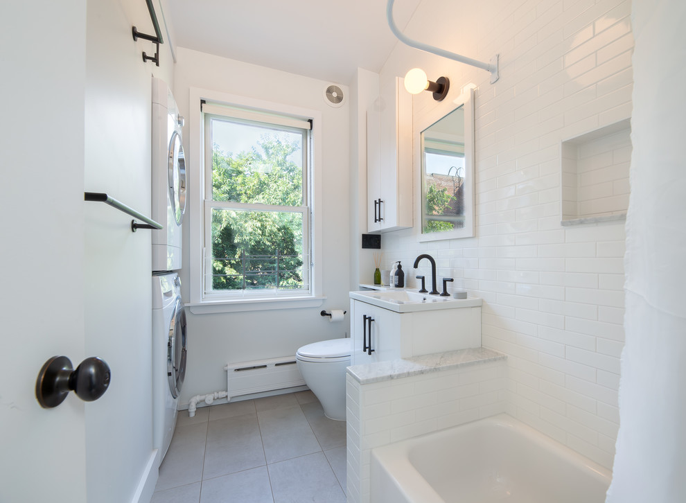 Источник вдохновения для домашнего уюта: ванная комната среднего размера со стиральной машиной в стиле неоклассика (современная классика) с плоскими фасадами, белыми фасадами, ванной в нише, душем над ванной, раздельным унитазом, белой плиткой, плиткой кабанчик, белыми стенами, полом из керамической плитки, душевой кабиной, монолитной раковиной, мраморной столешницей, бежевым полом, шторкой для ванной и серой столешницей