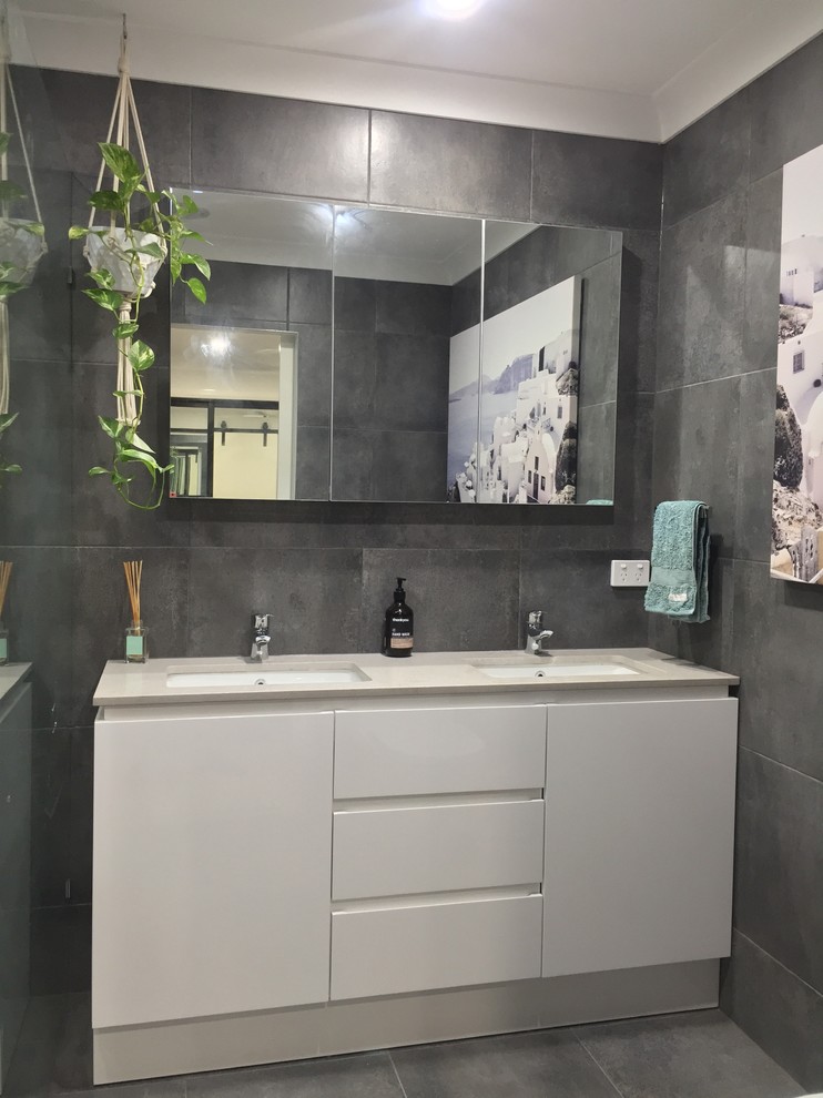 Small trendy ceramic tile ceramic tile and gray floor bathroom photo in Brisbane with a one-piece toilet, gray walls, an undermount sink, quartz countertops and beige countertops