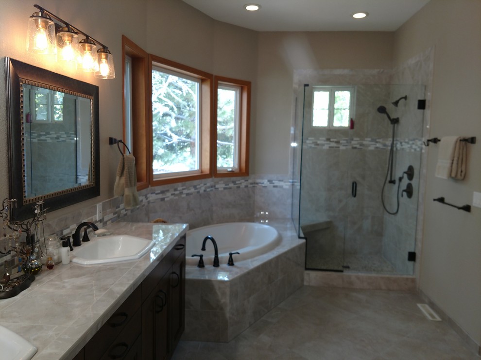 Bathroom - large traditional master gray tile and ceramic tile ceramic tile and beige floor bathroom idea in Boise with recessed-panel cabinets, dark wood cabinets, beige walls, a drop-in sink, tile countertops, a hinged shower door and gray countertops