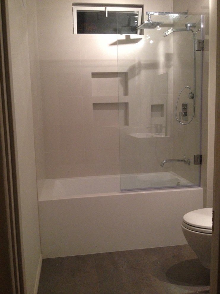 Idee per una piccola stanza da bagno moderna con lavabo sospeso, vasca ad alcova, vasca/doccia, WC sospeso, piastrelle grigie, pareti bianche e pavimento in gres porcellanato