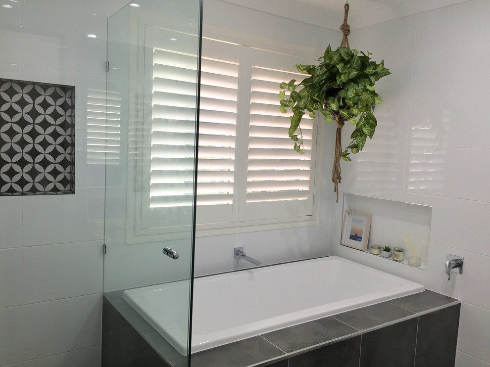 Inspiration for a mid-sized contemporary white tile and ceramic tile ceramic tile and gray floor drop-in bathtub remodel in Brisbane with a one-piece toilet, white walls, an undermount sink, quartz countertops, a hinged shower door and beige countertops