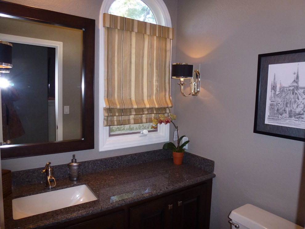 На фото: ванная комната среднего размера в современном стиле с фасадами с выступающей филенкой, темными деревянными фасадами, раздельным унитазом, серыми стенами, врезной раковиной и столешницей из гранита