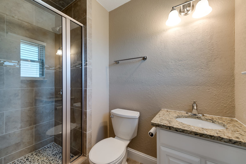 Foto på ett litet vintage en-suite badrum, med luckor med infälld panel, vita skåp, beige kakel och granitbänkskiva