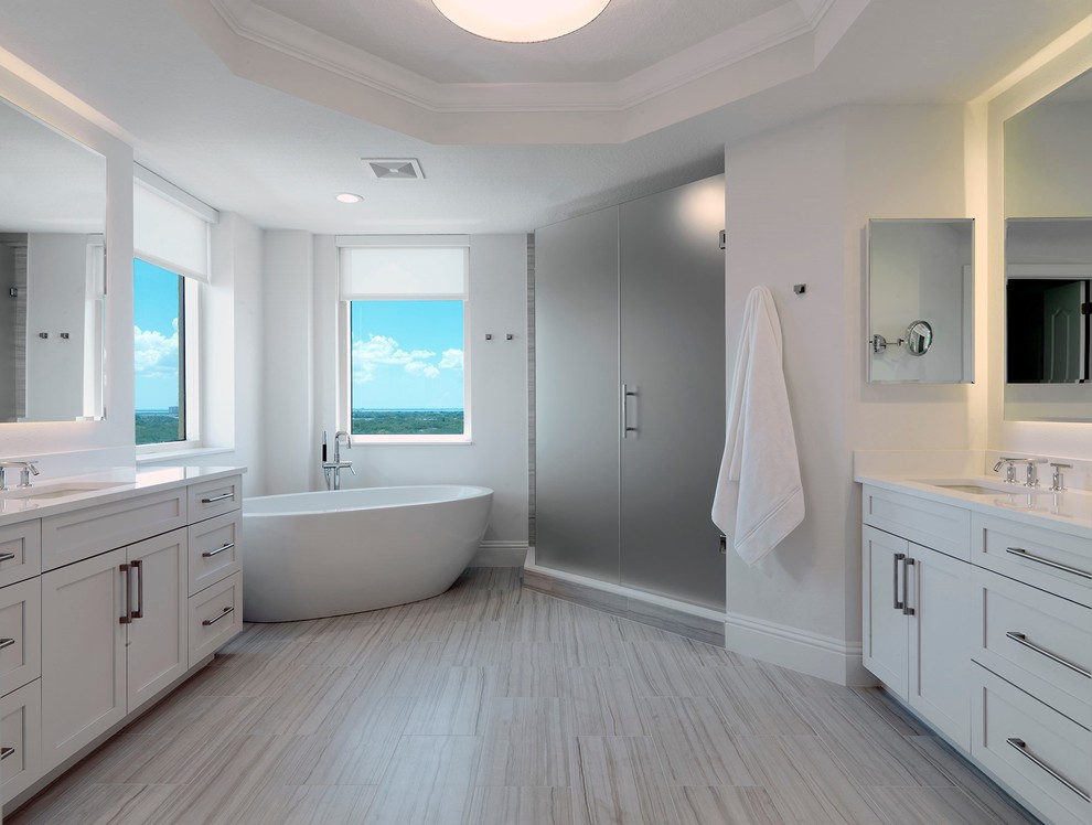 Inspiration for a large classic ensuite bathroom in Tampa with shaker cabinets, white cabinets, a freestanding bath, an alcove shower, white walls, vinyl flooring, a submerged sink, engineered stone worktops, grey floors and a hinged door.
