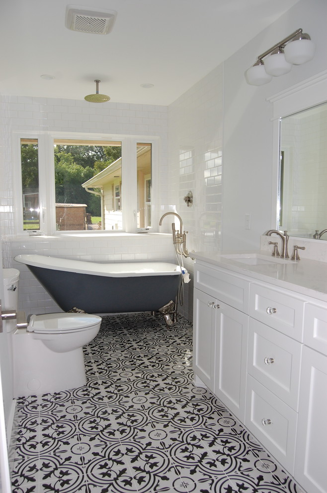 Lantlig inredning av ett mellanstort vit vitt badrum med dusch, med skåp i shakerstil, vita skåp, ett fristående badkar, en öppen dusch, en toalettstol med separat cisternkåpa, vit kakel, tunnelbanekakel, grå väggar, cementgolv, ett undermonterad handfat, bänkskiva i akrylsten, vitt golv och dusch med duschdraperi