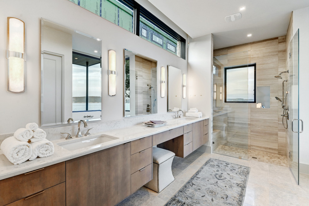 Trendy master beige tile and brown tile beige floor and double-sink alcove shower photo in Austin with flat-panel cabinets, medium tone wood cabinets, white walls, a hinged shower door, white countertops and a floating vanity