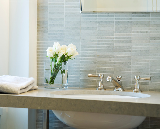 Esempio di una stanza da bagno padronale minimalista di medie dimensioni con piastrelle grigie, lastra di pietra, pareti bianche e lavabo integrato