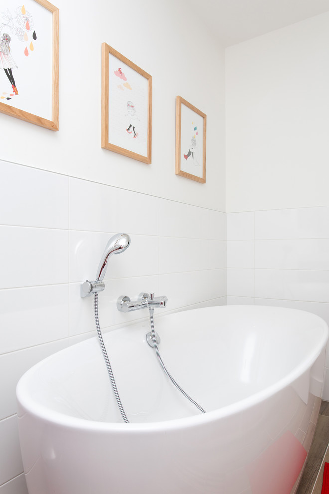 Стильный дизайн: главная ванная комната среднего размера в современном стиле с отдельно стоящей ванной, душем над ванной, белой плиткой и белыми стенами - последний тренд