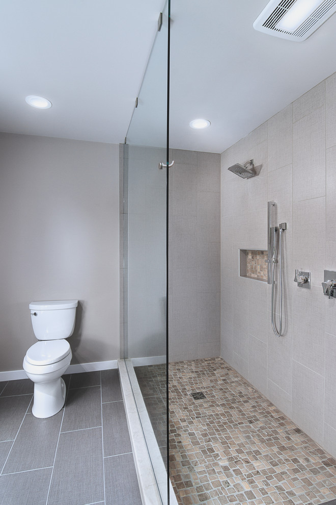 Design ideas for a medium sized classic ensuite bathroom in Philadelphia with freestanding cabinets, grey cabinets, a freestanding bath, a built-in shower, a two-piece toilet, grey tiles, porcelain tiles, grey walls, porcelain flooring, a submerged sink, engineered stone worktops, black floors and an open shower.