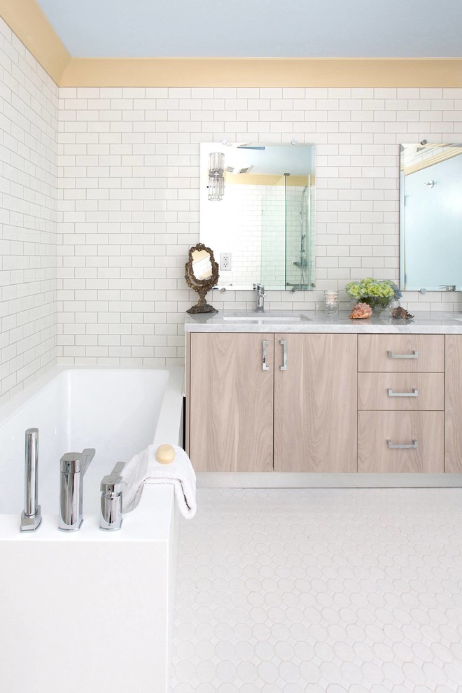 Exempel på ett klassiskt badrum, med ett undermonterad handfat, släta luckor, skåp i ljust trä, marmorbänkskiva, ett hörnbadkar, en kantlös dusch, en toalettstol med hel cisternkåpa, vit kakel och keramikplattor