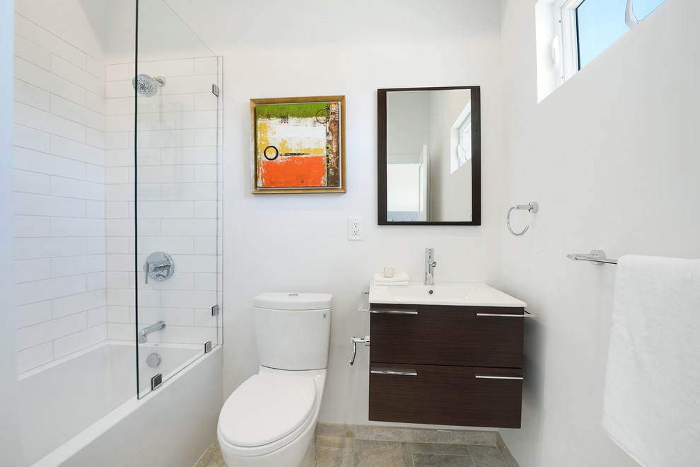 Example of a mid-sized transitional kids' white tile and ceramic tile porcelain tile alcove bathtub design in Los Angeles with flat-panel cabinets, dark wood cabinets, a two-piece toilet, white walls, a drop-in sink and quartz countertops