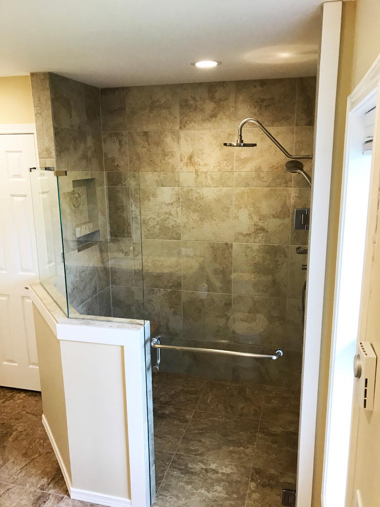 Photo of a large classic ensuite bathroom in Seattle with shaker cabinets, brown cabinets, a corner shower, a one-piece toilet, beige tiles, porcelain tiles, yellow walls, porcelain flooring, a submerged sink, quartz worktops, beige floors and a hinged door.
