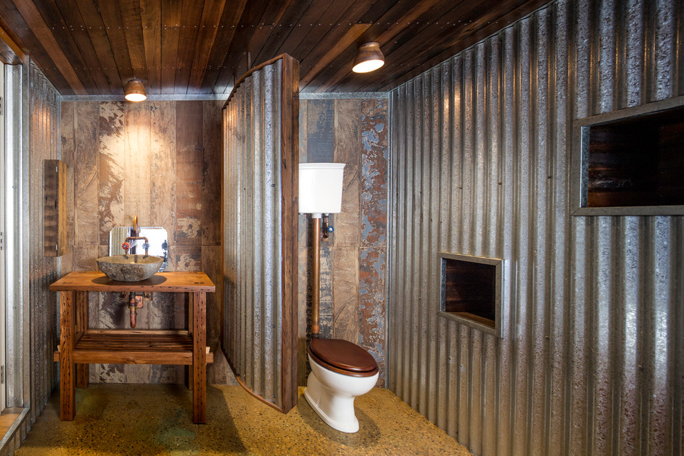 Inspiration för ett mellanstort industriellt brun brunt badrum, med öppna hyllor, en toalettstol med separat cisternkåpa, betonggolv, ett fristående handfat och träbänkskiva