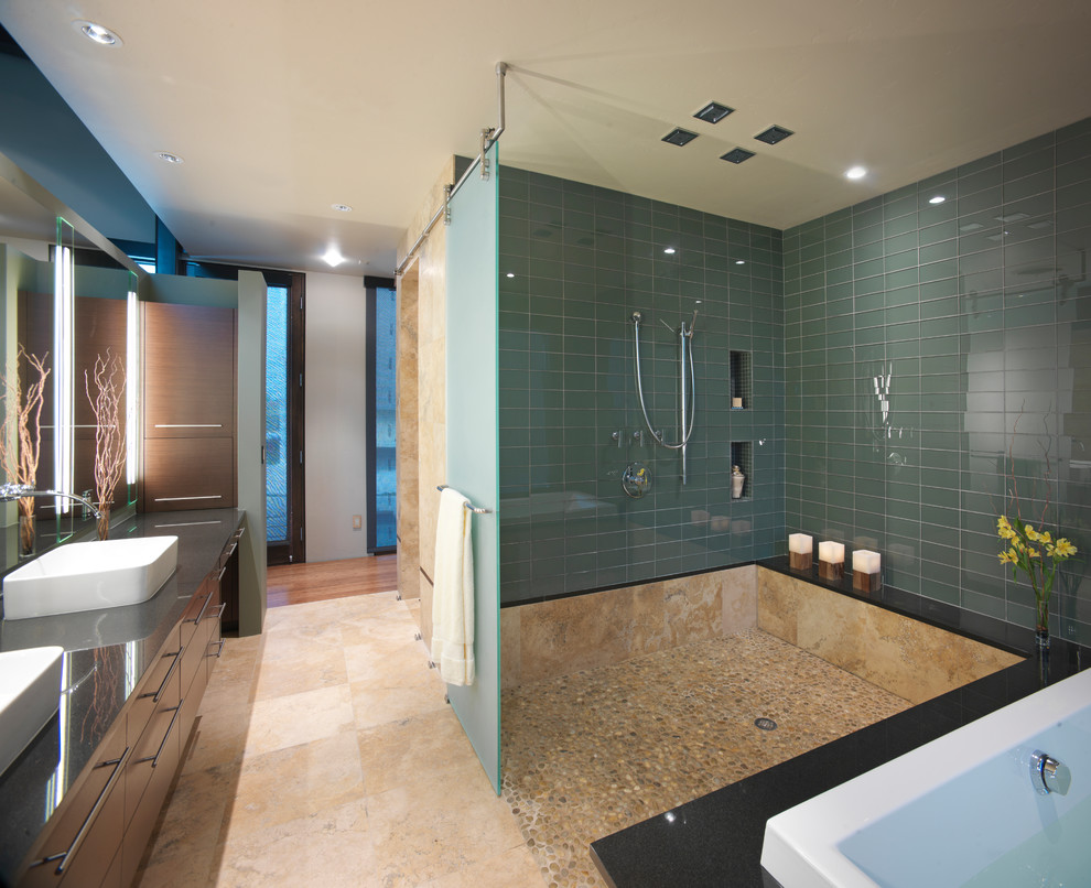 Bild på ett funkis grå grått badrum, med en öppen dusch, tunnelbanekakel, ett fristående handfat och med dusch som är öppen