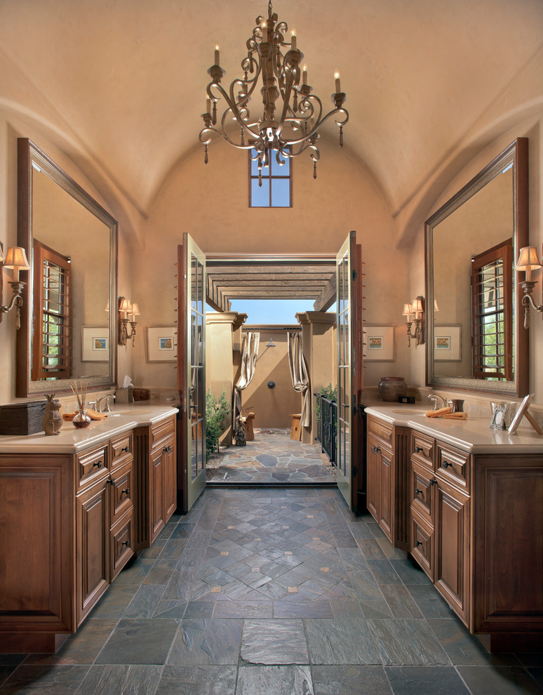 Idee per una stanza da bagno mediterranea con ante con bugna sagomata, ante in legno bruno e pareti beige