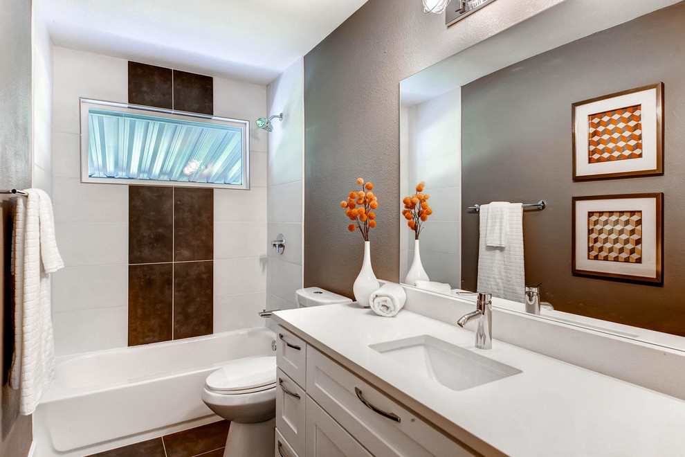Modern inredning av ett badrum, med skåp i shakerstil, vita skåp, ett badkar i en alkov, en dusch/badkar-kombination, en toalettstol med hel cisternkåpa, bruna väggar och ett undermonterad handfat