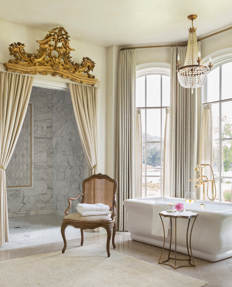 Foto på ett stort vintage en-suite badrum, med ett fristående badkar, en dusch i en alkov, grå kakel, vit kakel, beige väggar, beiget golv, dusch med duschdraperi och marmorbänkskiva