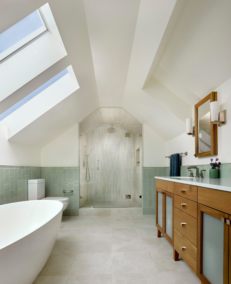 Inredning av ett modernt en-suite badrum, med släta luckor, skåp i mellenmörkt trä, ett fristående badkar, en kantlös dusch, gröna väggar, beiget golv och dusch med gångjärnsdörr