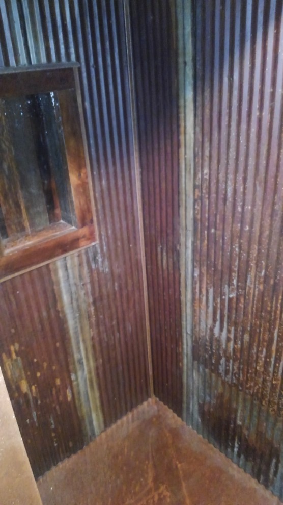 Cette image montre une petite salle d'eau chalet avec une douche d'angle, un carrelage marron, carrelage en métal et aucune cabine.