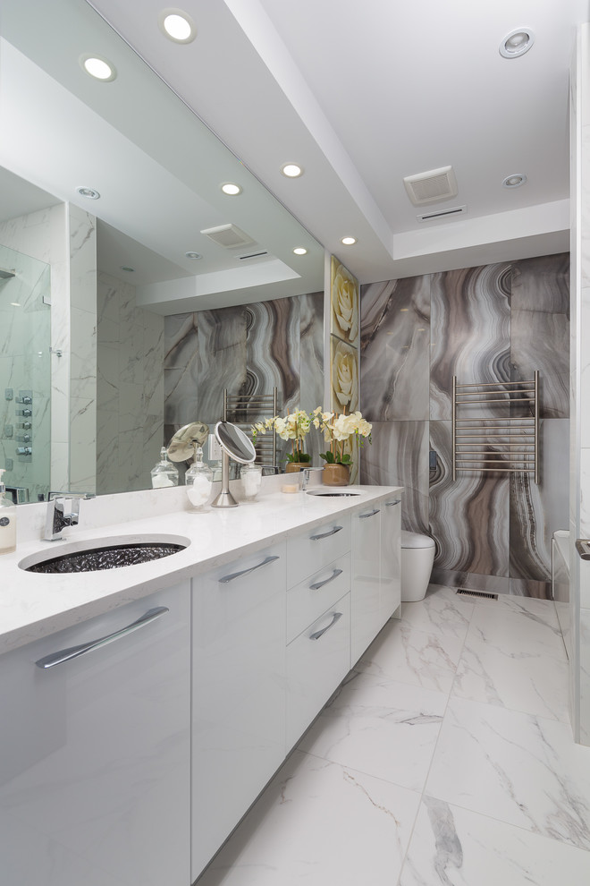 Modern inredning av ett mellanstort vit vitt en-suite badrum, med släta luckor, gula skåp, en toalettstol med hel cisternkåpa, stenhäll, marmorgolv, ett undermonterad handfat, bänkskiva i kvartsit och vitt golv
