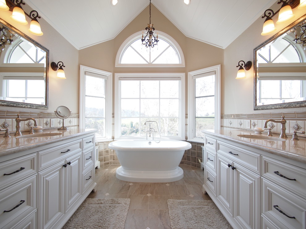 Exempel på ett stort klassiskt en-suite badrum, med luckor med infälld panel, vita skåp, ett fristående badkar, en dusch i en alkov, en toalettstol med separat cisternkåpa, beige kakel, brun kakel, vit kakel, cementkakel, beige väggar, klinkergolv i porslin, ett undermonterad handfat, granitbänkskiva, brunt golv och dusch med gångjärnsdörr