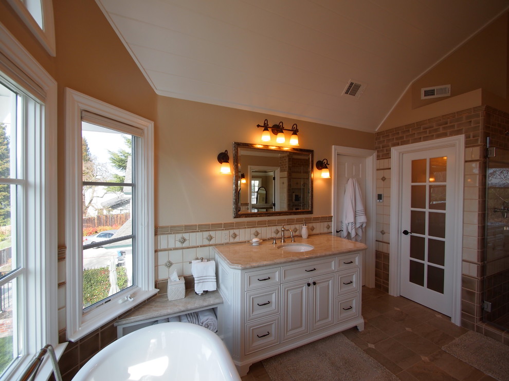 Example of a large transitional master beige tile, brown tile, white tile and cement tile porcelain tile and brown floor bathroom design in San Francisco with recessed-panel cabinets, white cabinets, a two-piece toilet, beige walls, an undermount sink, granite countertops and a hinged shower door