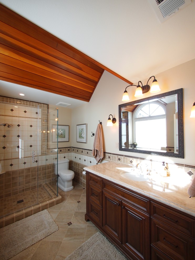 На фото: главная ванная комната среднего размера в классическом стиле с фасадами с выступающей филенкой, темными деревянными фасадами, душем в нише, раздельным унитазом, бежевой плиткой, коричневой плиткой, белой плиткой, цементной плиткой, бежевыми стенами, полом из керамической плитки, врезной раковиной, мраморной столешницей, коричневым полом и душем с распашными дверями с