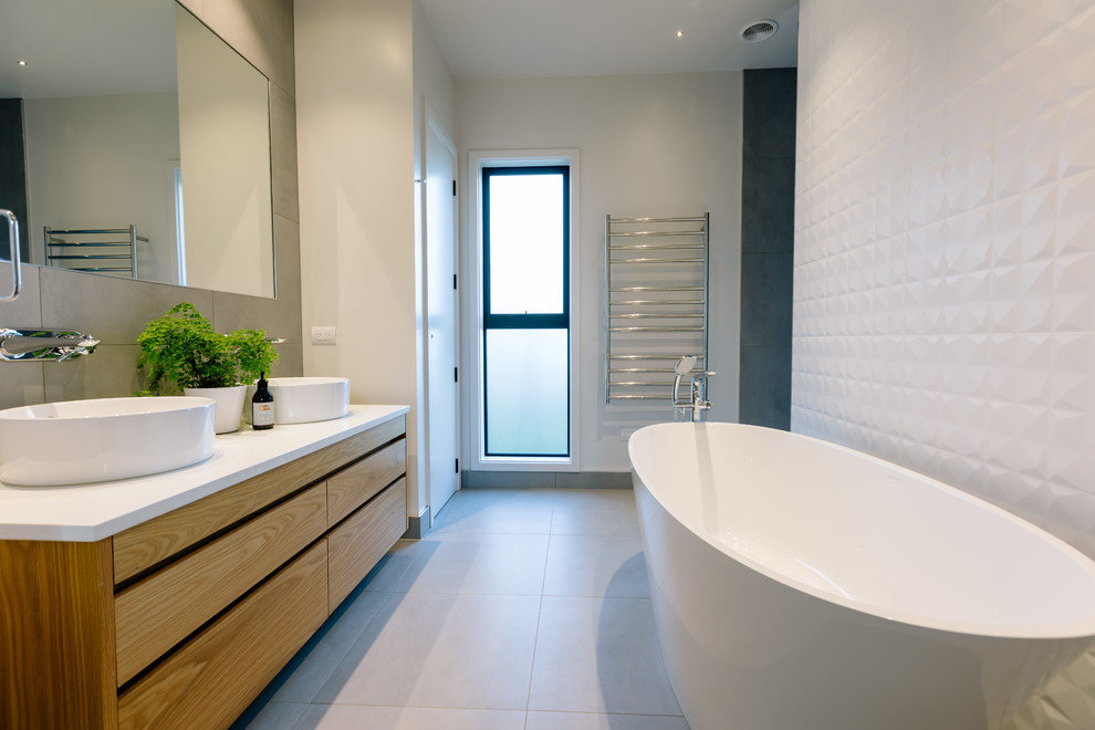 Ejemplo de cuarto de baño principal de estilo de casa de campo con armarios con paneles lisos, puertas de armario de madera oscura, paredes blancas, lavabo sobreencimera, suelo gris y encimeras blancas
