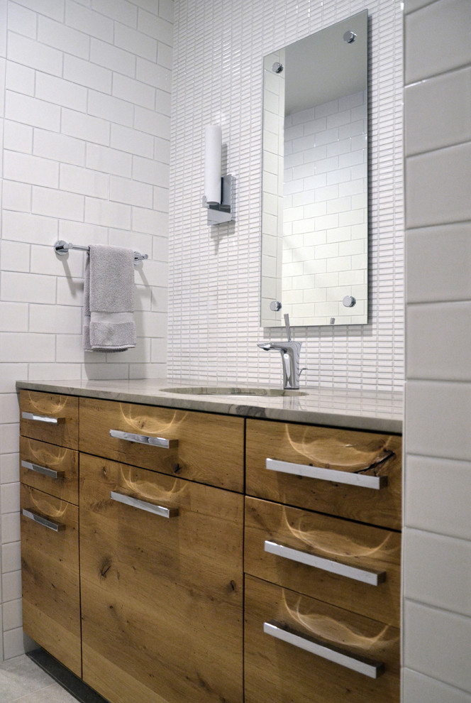 Exempel på ett stort modernt en-suite badrum, med ett undermonterad handfat, släta luckor, skåp i ljust trä, marmorbänkskiva, ett badkar i en alkov, en dusch/badkar-kombination, en toalettstol med hel cisternkåpa, vit kakel, keramikplattor, vita väggar och klinkergolv i porslin