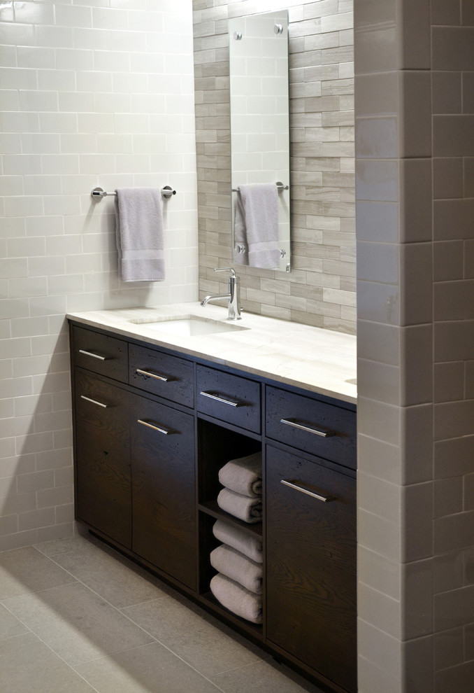 Large modern bathroom in Chicago with a submerged sink, flat-panel cabinets, dark wood cabinets, marble worktops, a one-piece toilet, grey tiles, stone tiles, grey walls and porcelain flooring.