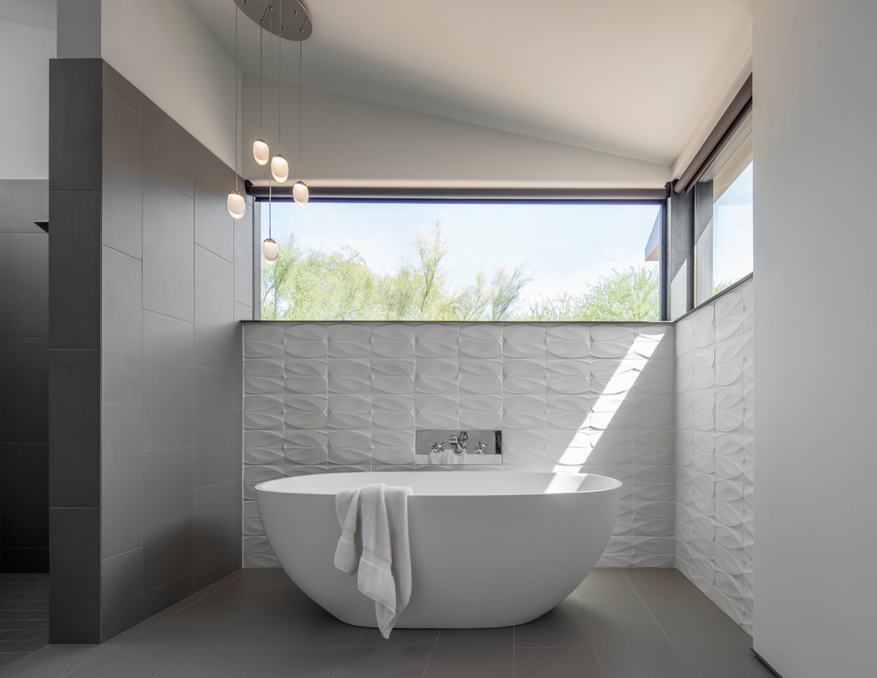 Foto de cuarto de baño principal contemporáneo con bañera exenta, baldosas y/o azulejos grises, paredes multicolor y suelo gris