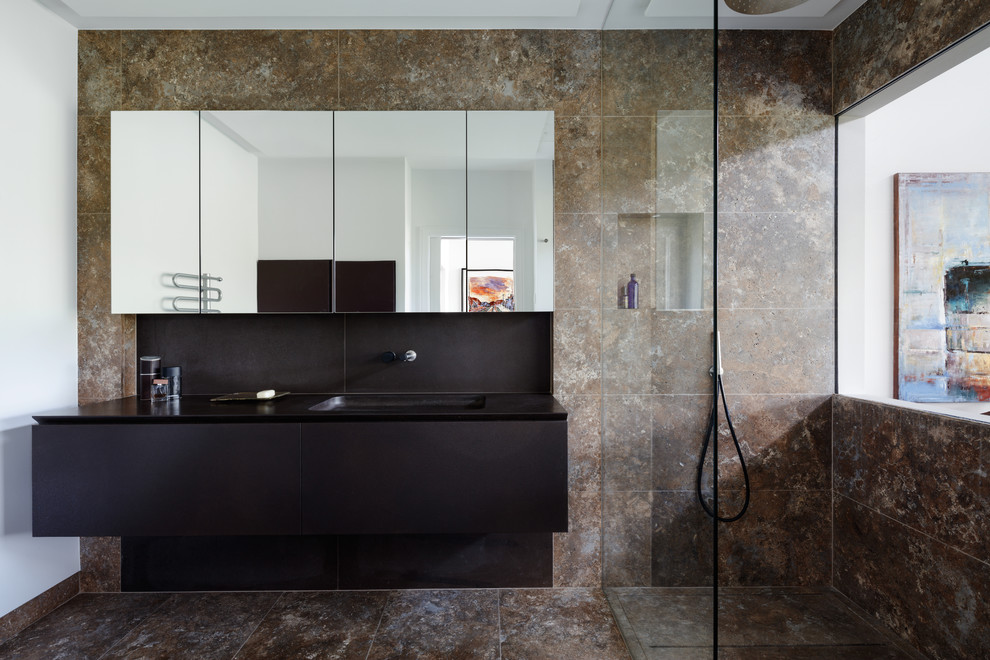 Inspiration for a large contemporary bathroom in London with flat-panel cabinets, brown tiles, limestone tiles, brown walls, limestone flooring, brown floors, an open shower, brown cabinets and a submerged sink.