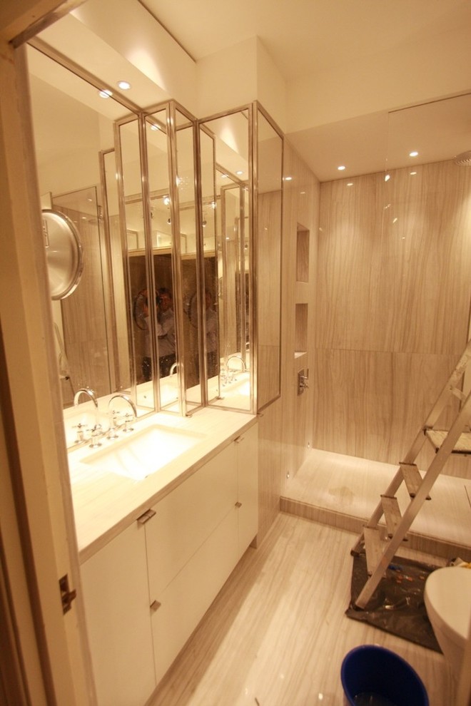 Ispirazione per una stanza da bagno padronale minimal di medie dimensioni con lavabo sottopiano, ante di vetro, ante bianche, top in marmo, vasca sottopiano, WC a due pezzi, lastra di pietra, pareti rosa, pavimento in marmo e piastrelle beige