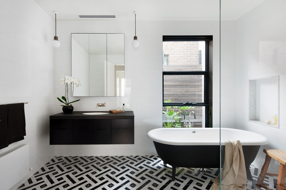 Источник вдохновения для домашнего уюта: главная ванная комната в современном стиле с плоскими фасадами, черными фасадами, ванной на ножках, белыми стенами, врезной раковиной и разноцветным полом