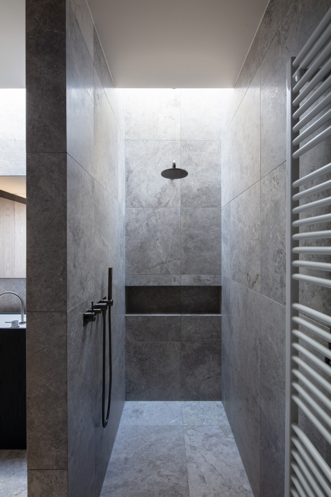 Modelo de cuarto de baño principal minimalista con ducha empotrada, baldosas y/o azulejos grises, ducha abierta y suelo gris